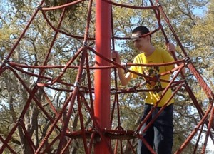 Danny on the jungle gym climbing.