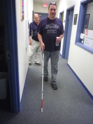 A male client with his white cane and his instructor