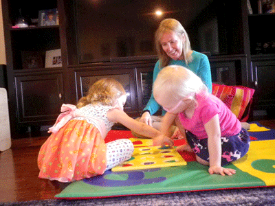 Becky on the floor with the girls with education toys