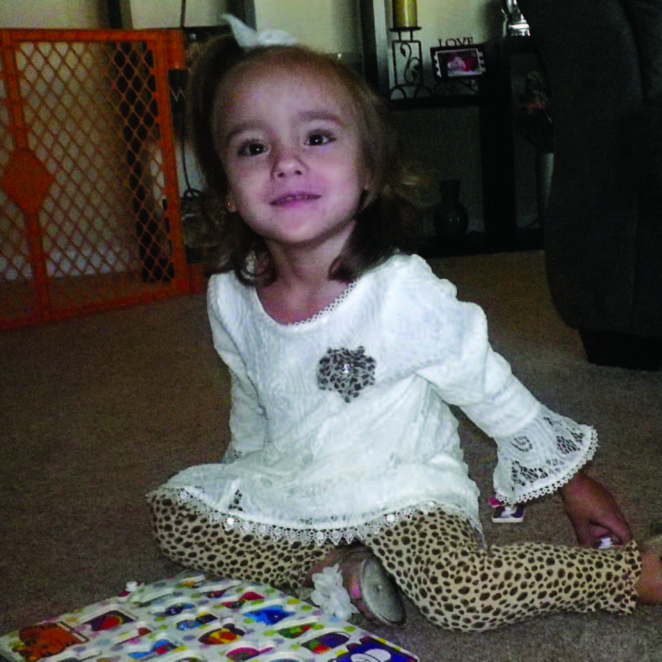 Abbey sits with her puzzle, smiling